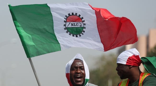 A protester waves a flag of the National Labour Congress NLC during a protest in Abuja