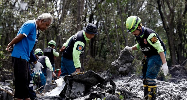 Rescue workers look through the wreckage of a small aircraft in Thailands Chachoengsao province on