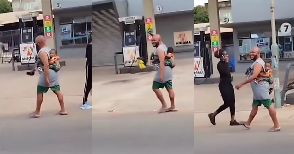 “Husband material” – Man spotted joyfully strolling with a child on his back in Onitsha (WATCH)