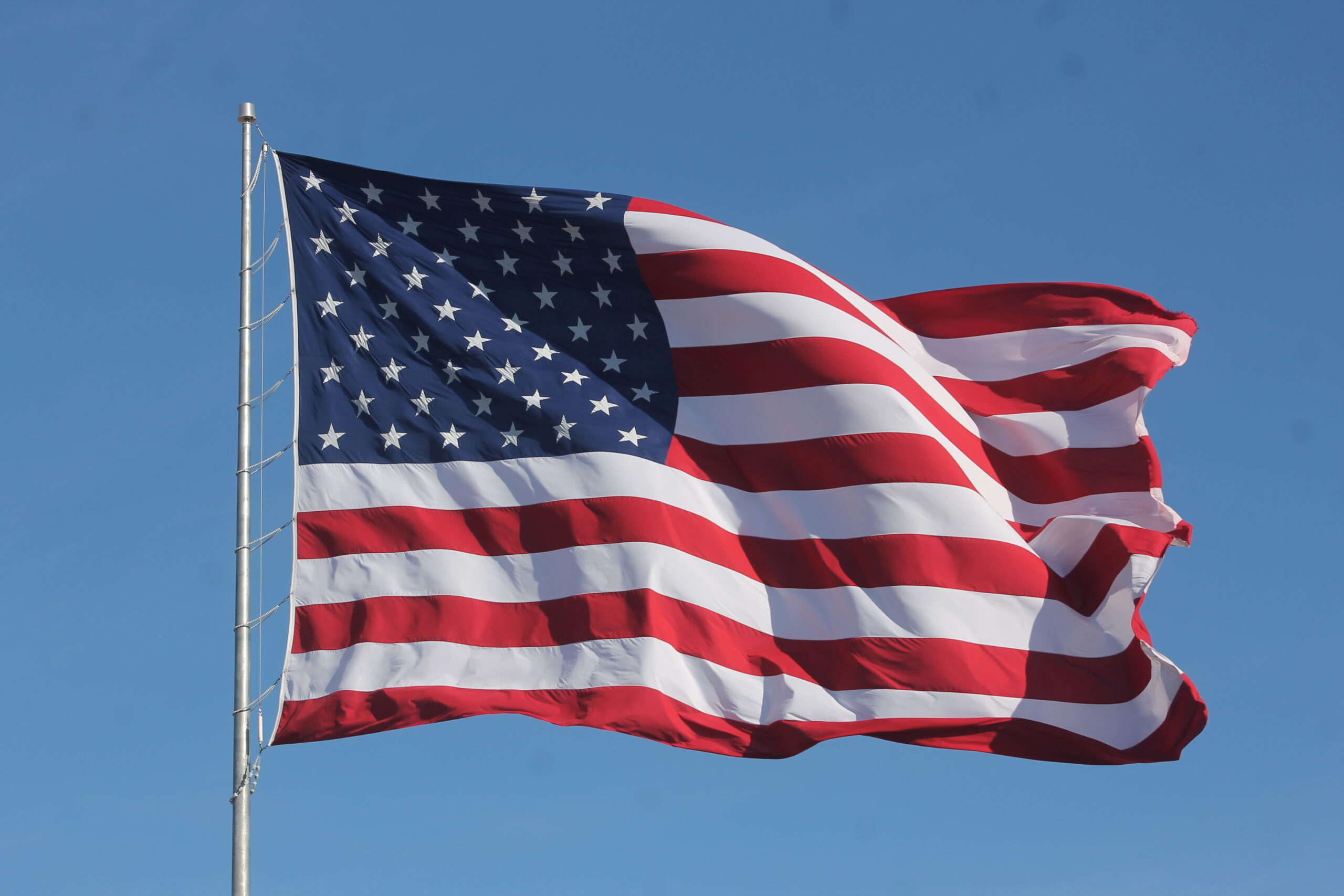 American Flag Waving on a Flag Pole scaled