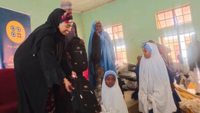 Katsina State Commissioner of Education Zainab Musawa presenting the leaning material to a student d