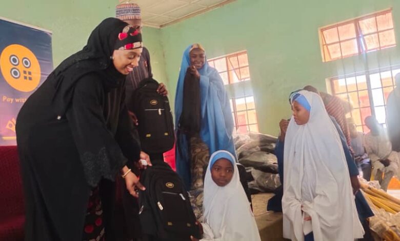 Katsina State Commissioner of Education Zainab Musawa presenting the leaning material to a student d