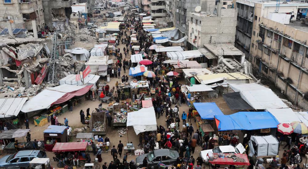 Palestinians walk on a street market amid ceasefire negotiations in Khan Younis in the southern Gaza