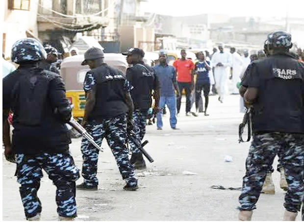 Policemen at a crime scene on cult clash